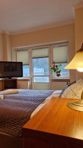 - une chambre avec un lit, une table et des fenêtres dans l'établissement Apartament Gwiazda 306, à Krynica-Zdrój