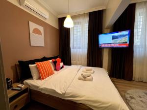 a bedroom with a bed with a tv on the wall at ComeLiveGO Cihangir 12 in Istanbul