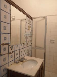 y baño con lavabo y espejo. en Pousada Inaya, en Petrópolis
