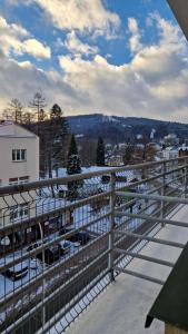 a balcony with a view of a parking lot with snow at Apartament Gwiazda 306 in Krynica Zdrój