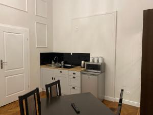 małą kuchnię ze stołem i kuchenką mikrofalową w obiekcie ROYAL Apartments w Krakowie