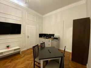 jadalnia ze stołem i krzesłami oraz kuchnia w obiekcie ROYAL Apartments w Krakowie