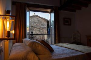 ein Schlafzimmer mit einem Bett und einem großen Fenster in der Unterkunft Casa Dona Ildara in Doade