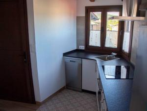 a small kitchen with a sink and a counter at Casa Dona Ildara in Doade