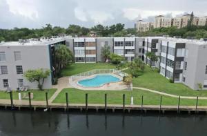 an apartment complex with a swimming pool next to the water at Designer River View Apartments in Fort Lauderdale