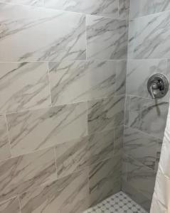 y baño con ducha y azulejos de mármol. en Designer River View Apartments en Fort Lauderdale