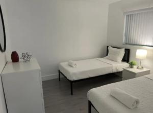 a white room with two beds and a couch at Designer River View Apartments in Fort Lauderdale