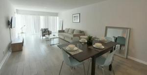 a living room with a table and chairs and a couch at Designer River View Apartments in Fort Lauderdale