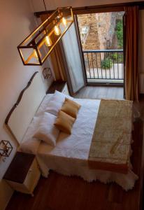 ein Schlafzimmer mit einem Bett, einer Lampe und einem Fenster in der Unterkunft Casa Dona Ildara in Doade