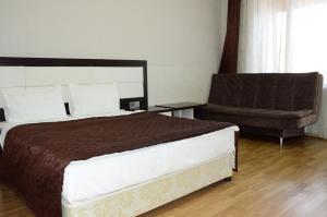 a bedroom with a large bed and a couch at Cozy Family Cottages in Vǝndam