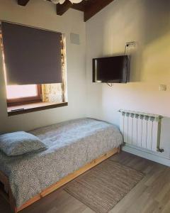 a bedroom with a bed and a flat screen tv at Casa Vilar (Taboadela-Ourense) in Taboadela
