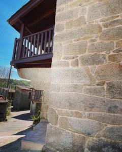 - un bâtiment en briques avec un balcon au-dessus dans l'établissement Casa Vilar (Taboadela-Ourense), à Taboadela