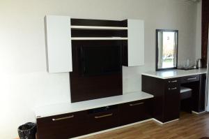 a kitchen with a tv on a wall at Cozy Family Cottages in Vǝndam