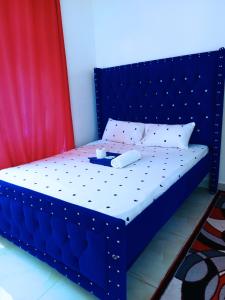 łóżko z niebieskim zagłówkiem z tacą w obiekcie Bamburi Luxury Homes 2 w mieście Bamburi