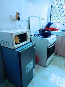 - un four micro-ondes installé au-dessus d'une poubelle dans la cuisine dans l'établissement Bamburi Luxury Homes 2, à Bamburi