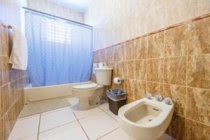 een badkamer met toilet, bad en wastafel bij Colinas Del Atlantico 2 floors in Isabela