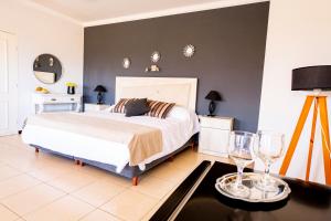 a bedroom with a bed and two wine glasses at Hotel Cuesta de Miranda in Villa Unión