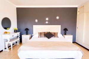 a bedroom with a large white bed and two night stands at Hotel Cuesta de Miranda in Villa Unión