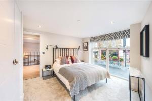 a bedroom with a bed and a large window at Fulham Townhouse, 2 Baths, Parking, Breakfast in London