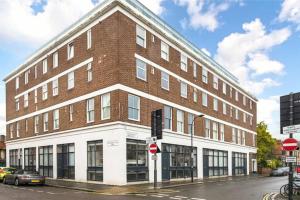 a large brick building on the corner of a street at Fulham Townhouse, 2 Baths, Parking, Breakfast in London