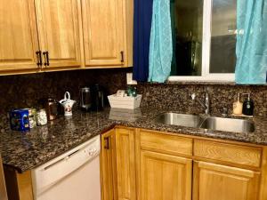 a kitchen with wooden cabinets and a sink at Charming Townhouse w/ Yard + BBQ in San Jose