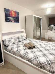 a bedroom with a bed with two slippers on it at Amity Luxury Home Dartford in Kent