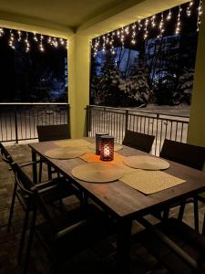 a wooden table with a candle on a balcony with lights at Apartmán Sirius in Štôla