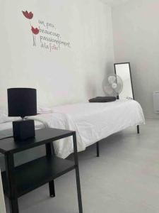 a bedroom with a bed and a table with a laptop on it at Appartement chaleureux pour 4 in Corbeil-Essonnes