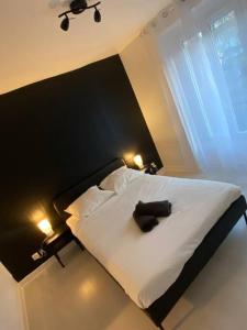 a bedroom with a white bed with a black headboard at Appartement chaleureux pour 4 in Corbeil-Essonnes