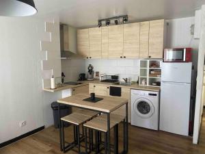 a kitchen with a table and a washing machine at Appartement chaleureux pour 4 in Corbeil-Essonnes