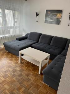 uma sala de estar com um sofá azul e uma mesa de centro em Reiheneckhaus mit Garten und Terasse em Tettnang