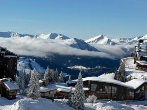 a ski lodge in the snow with snow covered mountains at Happy Yeti Avoriaz in Avoriaz