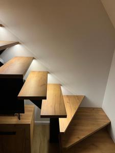 twee houten tafels in een kamer met trap bij Kuća za odmor ALTEA Pridolci in Busovača
