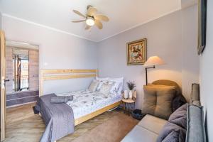 ein Schlafzimmer mit einem Bett und einer Couch in der Unterkunft Holiday Home Dalmatinka - 20m From the Beach in Splitska