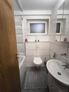 a white bathroom with a toilet and a sink at Haus am ruhige Lage in Langscheid Nähe sorpesee in Melschede