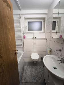 La salle de bains blanche est pourvue de toilettes et d'un lavabo. dans l'établissement Haus am ruhige Lage in Langscheid Nähe sorpesee, à Melschede