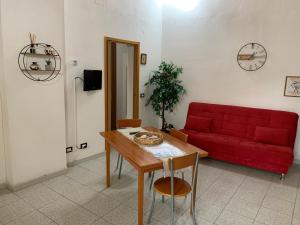 sala de estar con sofá rojo y mesa en Appartamento tranquillo a due passi dal centro, en Vigevano