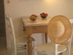 a table with two chairs and two bowls of fruit at Paros Apartments in Parikia