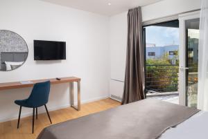 a bedroom with a bed and a desk and a window at Villa Roca with heated pool and sauna in Privlaka