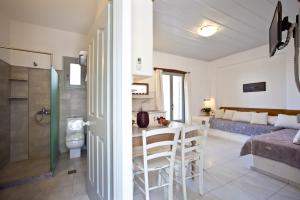 1 baño y 1 dormitorio con aseo y mesa. en Paros Apartments en Parikia