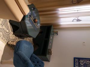 ein Wohnzimmer mit einem Stuhl und einem TV in der Unterkunft Mahdia Azur in Mahdia