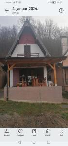 a house with a screened in porch with a roof at Vikendica Dunav i SAVA in Donji Milanovac