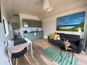 a living room with a couch and a table at Esehytter Luxury Holiday Home near Beach in Nørre Nebel