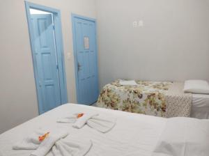 a bedroom with two beds and towels on a bed at Recanto das Estrelas in Marau