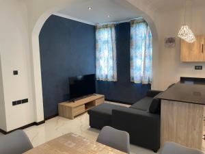 ein Wohnzimmer mit einem Sofa und einem TV in der Unterkunft Mont Choisy Cosy Apartment in Pamplemousses Village