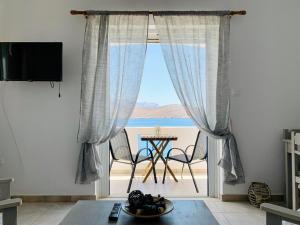 a living room with a large window with a view of the ocean at Aegean Aura Apartment II in Kalymnos