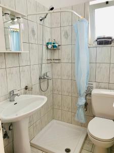a bathroom with a shower and a toilet and a sink at Aegean Aura Apartment II in Kalymnos +14 photos