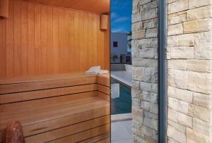 a wooden sauna with a stone wall at Villa Roca in Privlaka