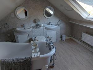 a bathroom with two sinks and two mirrors at Ensuite room The bungalow William Harvey hospital in Willesborough