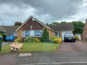 a house with a car parked in the driveway at Ensuite room The bungalow William Harvey hospital in Willesborough